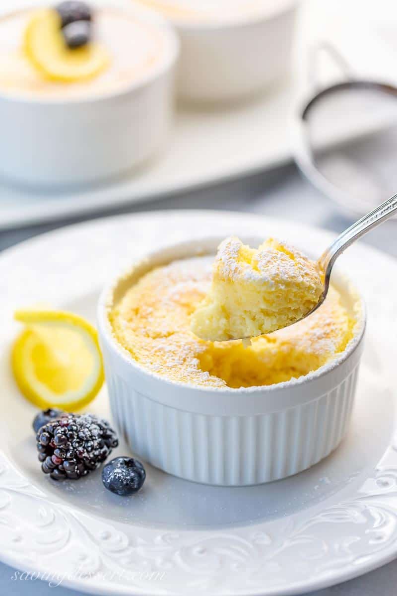 A spoonful of fluffy and light lemon pudding cake over a ramekin