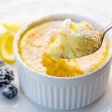 Lemon Pudding Cake on a plate with a spoonful showing the light and fluffy texture