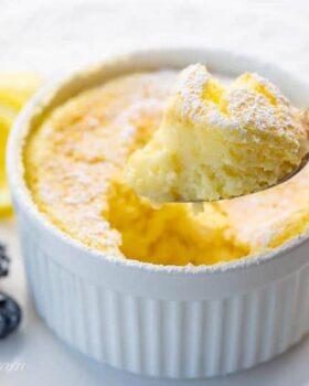 Lemon Pudding Cake on a plate with a spoonful showing the light and fluffy texture