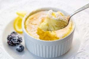 Lemon Pudding Cake on a plate with a spoonful showing the light and fluffy texture