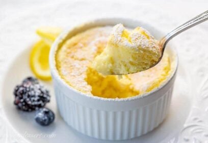 Lemon Pudding Cake on a plate with a spoonful showing the light and fluffy texture