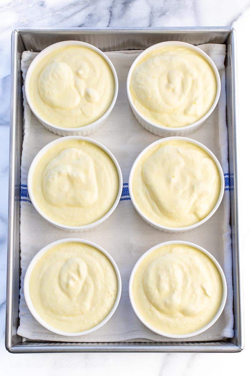 Cake batter spooned into 6 ramekins set inside a roasting pan