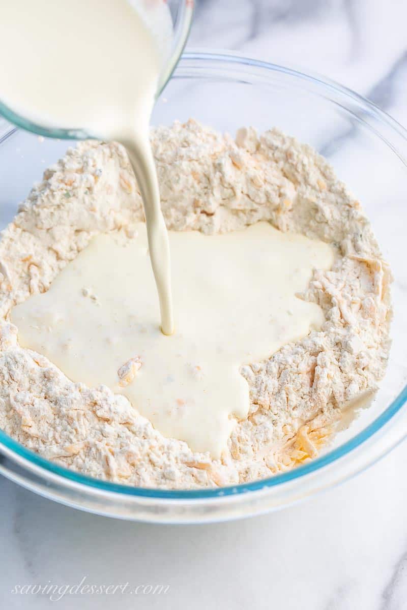 cheesy biscuit dough with heavy cream being pour in