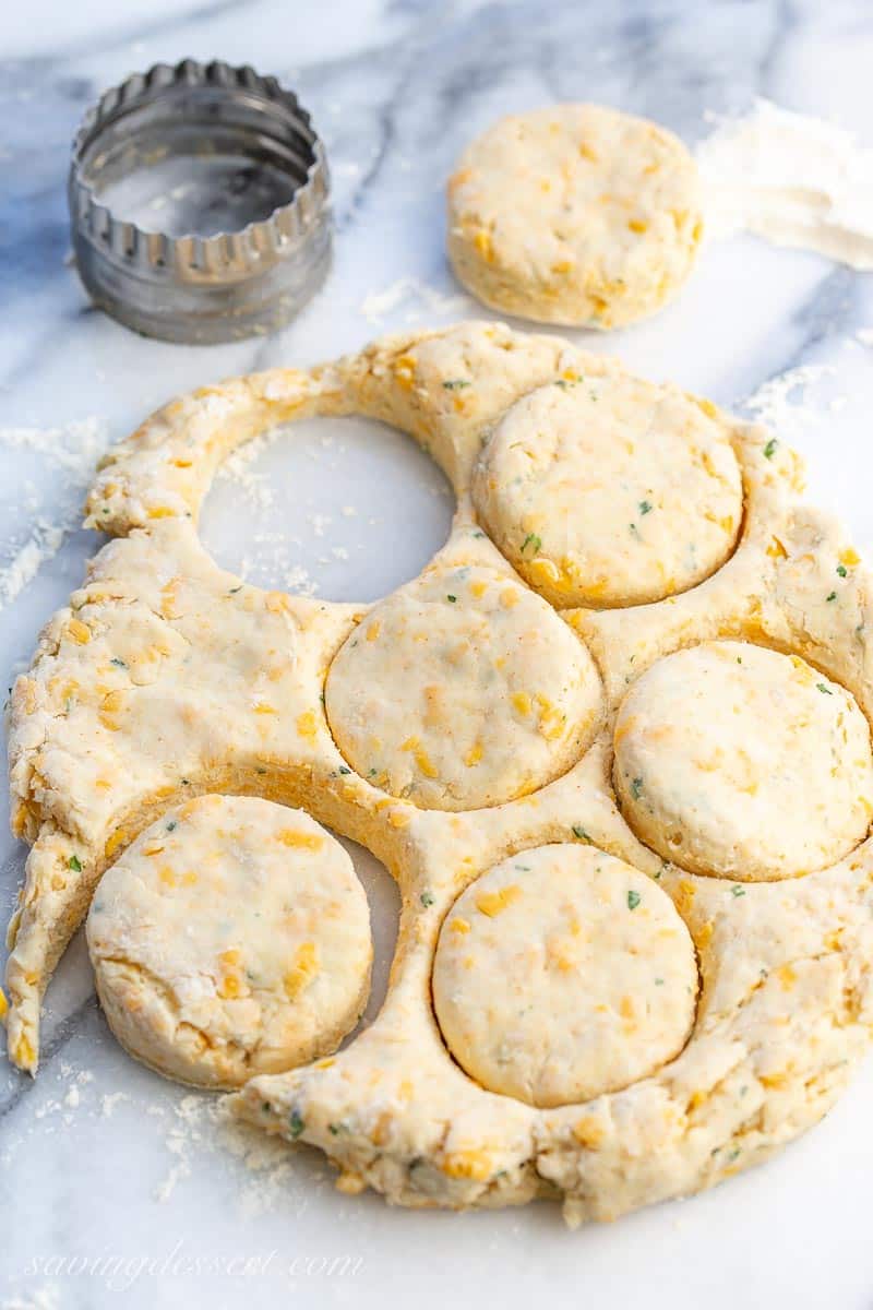 Biscuit dough with cheese and herbs being cut into rounds