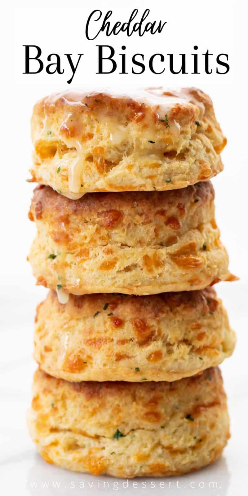 A stack of cheesy biscuits with butter dripping from the top