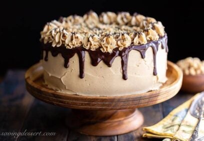 A peanut butter frosted chocolate cake with chocolate ganache dripping down the sides