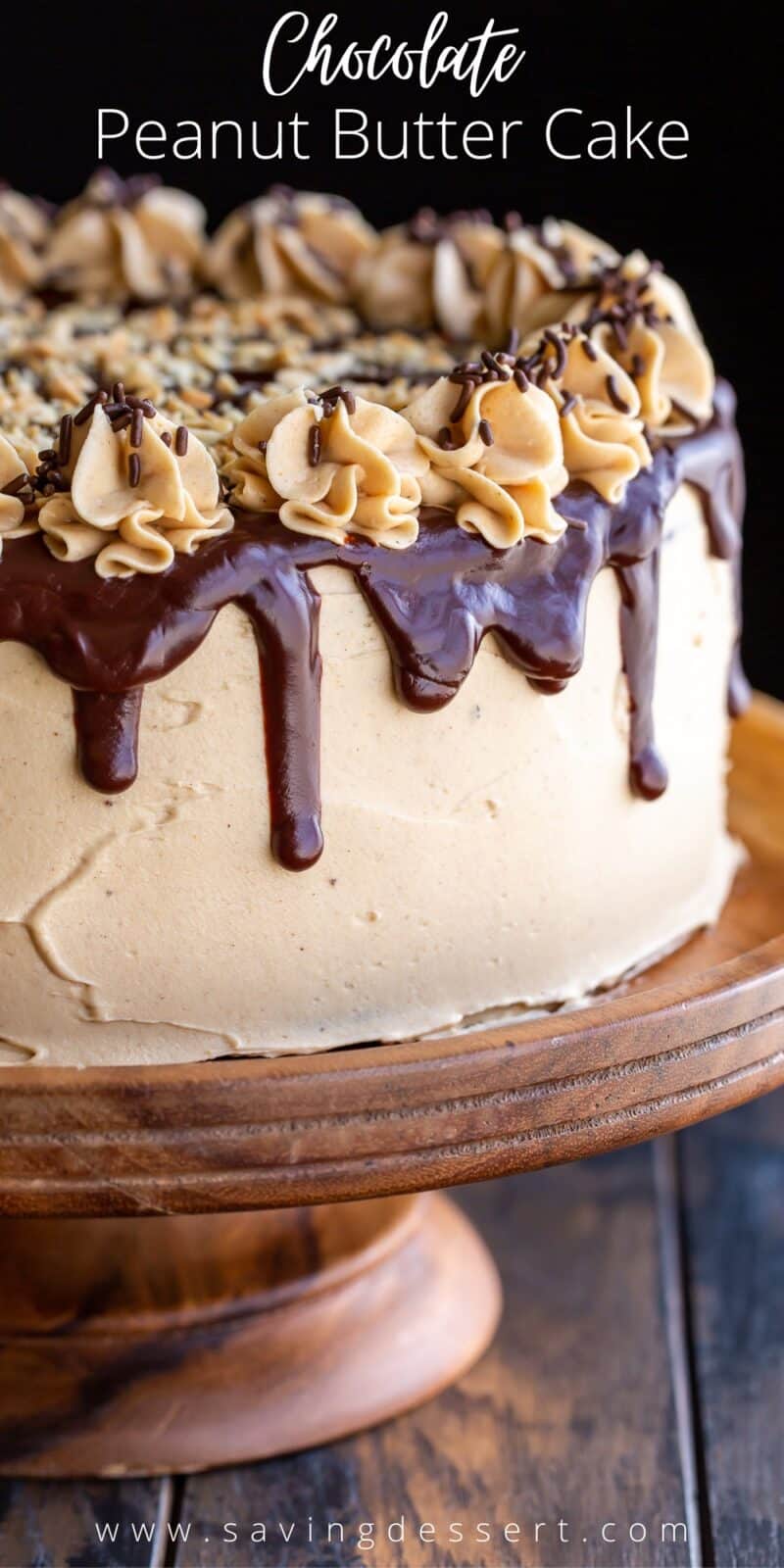 Chocolate Peanut Butter Cake on a wooden cake stand with chocolate ganache drips and swirls of peanut butter frosting