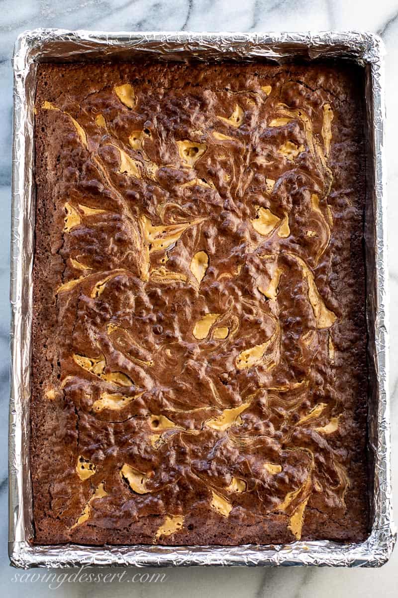 A pan of baked brownies with a peanut butter swirl on top