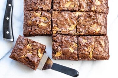 Overhead view of brownies cut into squares with one on a spatula