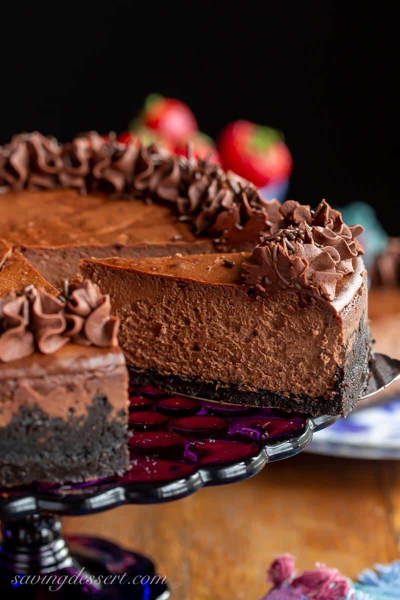 Chocolate cheese on a cake stand with one slice on a spatula