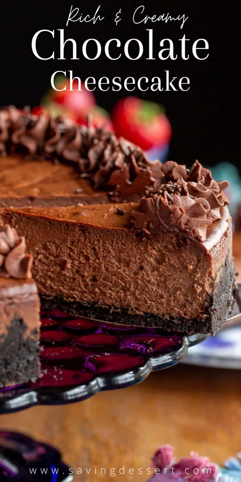 A slice of chocolate cheesecake on a platter with strawberries in the background