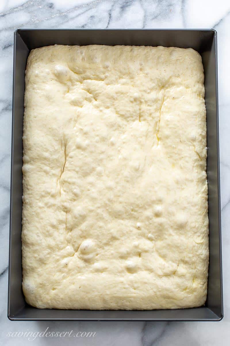 A pan of "risen" homemade pizza dough in a 13x9-inch pan