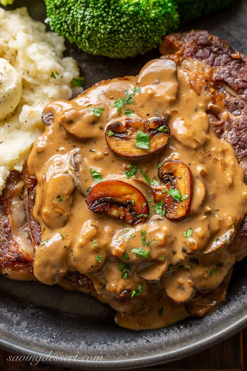 A closeup of mushroom sauce for steak on a plate with mashed potatoes