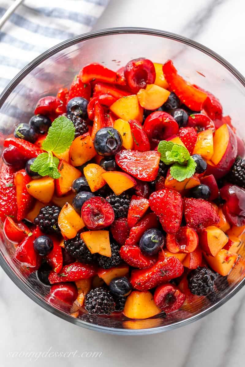 A bowl of fresh fruit salad garnished with mint leaves