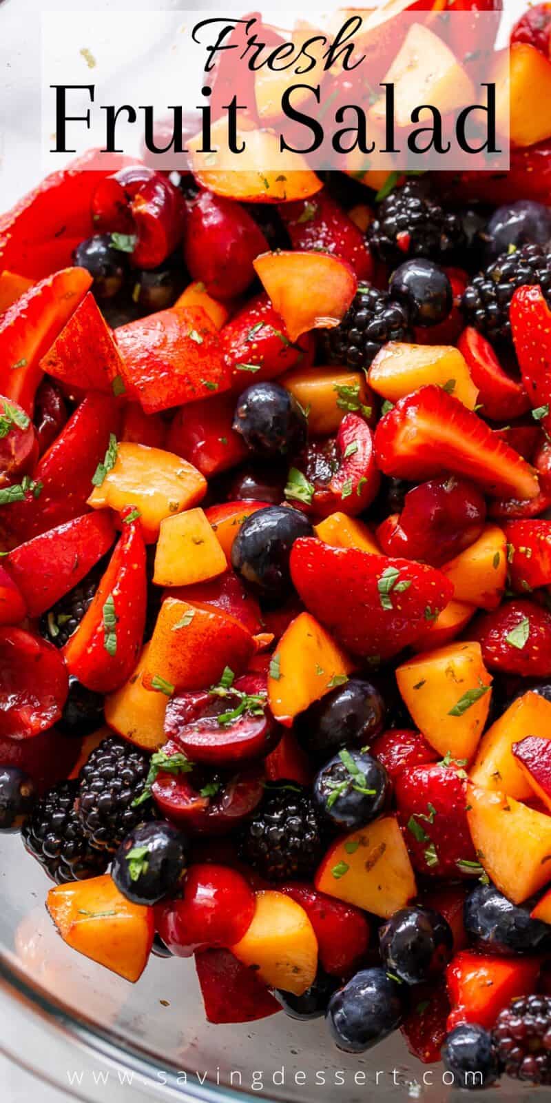 A closeup of a bowl of fresh fruit salad with cherries, blackberries, strawberries and blueberries