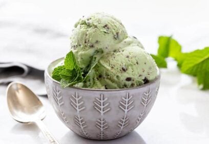 Closeup of a bowl of ice cream garnished with a sprig of mint