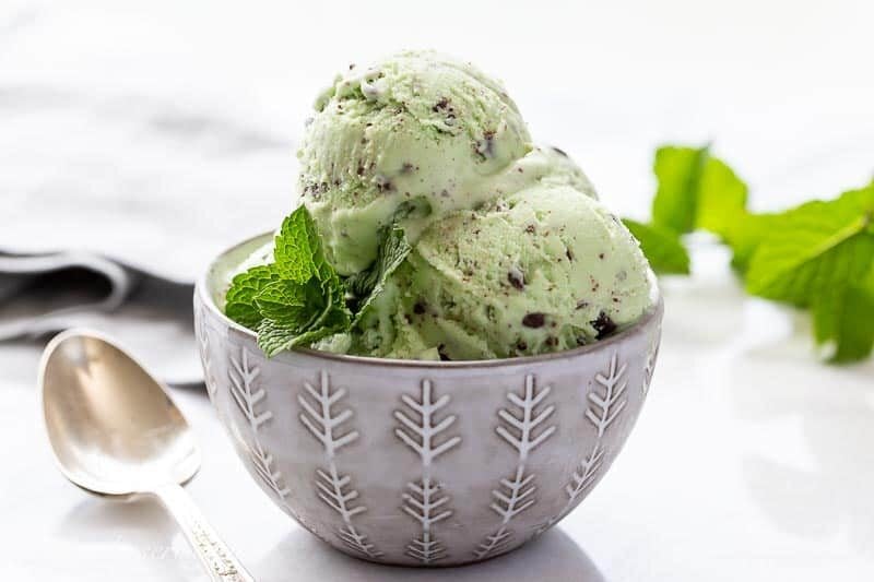 Closeup of a bowl of ice cream garnished with a sprig of mint