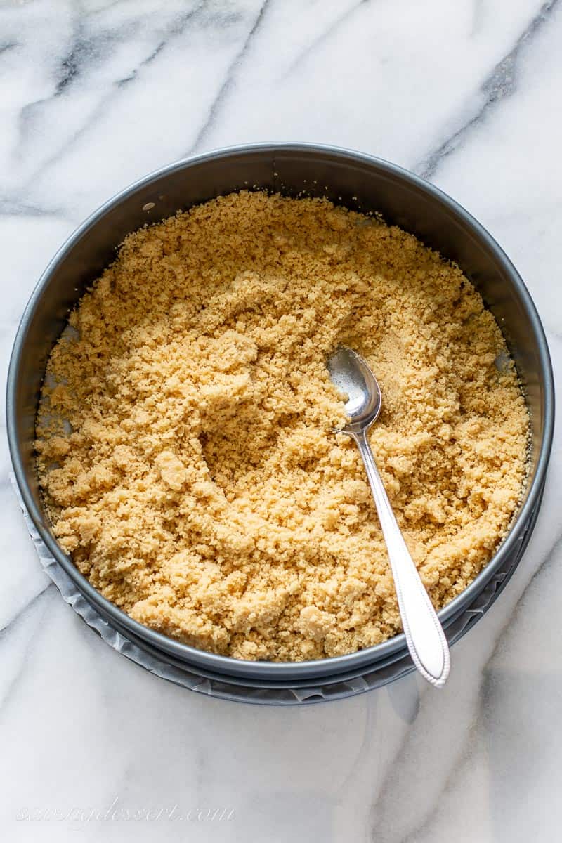 A spring form pan with crushed cookie crumbs