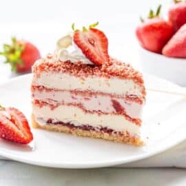 close up of a slice of strawberry ice cream crunch cake on a plate