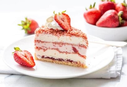 close up of a slice of strawberry ice cream crunch cake on a plate