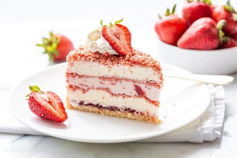 close up of a slice of strawberry ice cream crunch cake on a plate