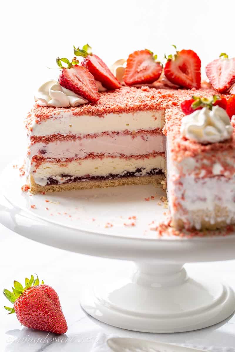 a side view of a sliced ice cream cake with layers of strawberry crumble