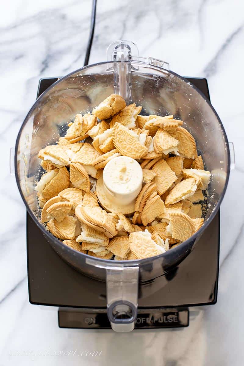 broken golden Oreo cookies in a food processor bowl