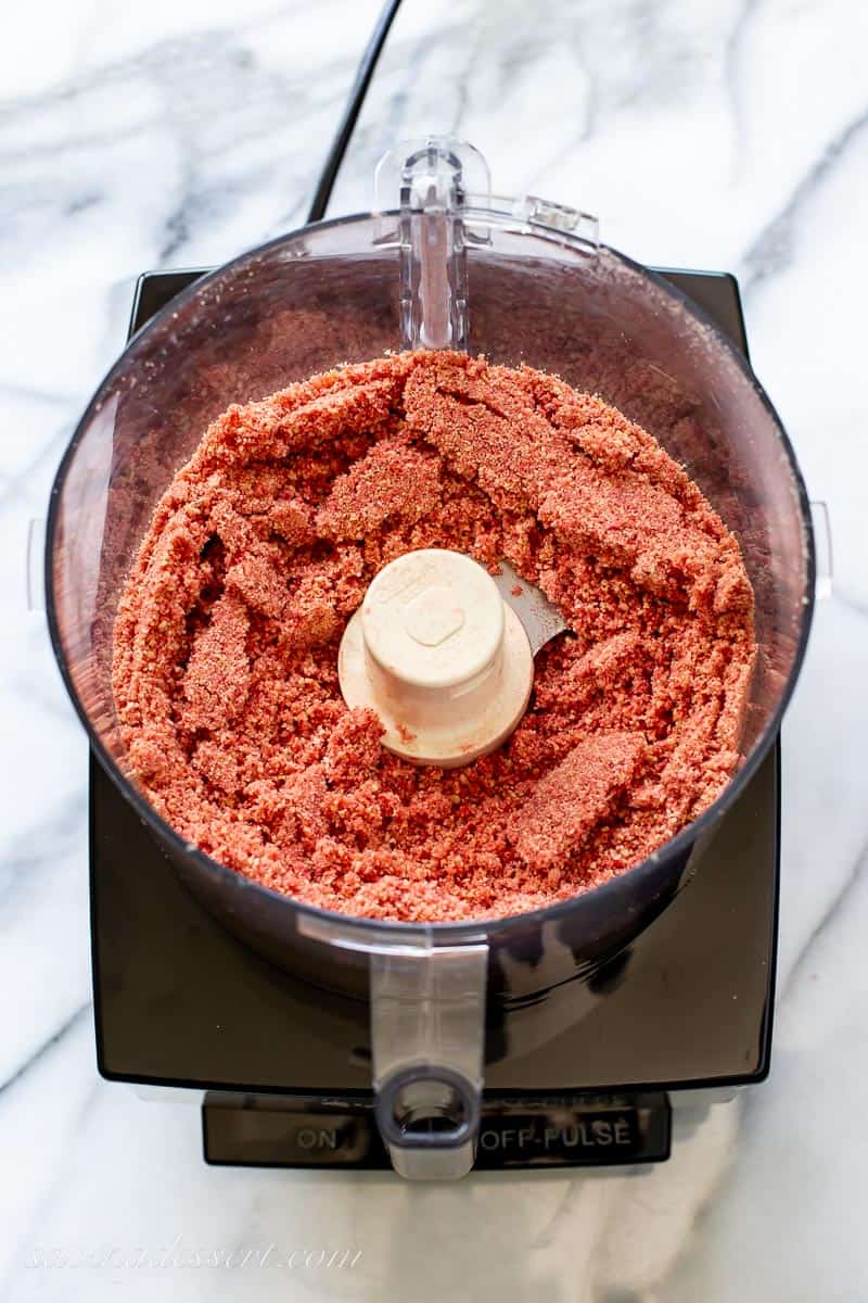 Crushed freeze dried strawberries and golden Oreo cookies in a food processor