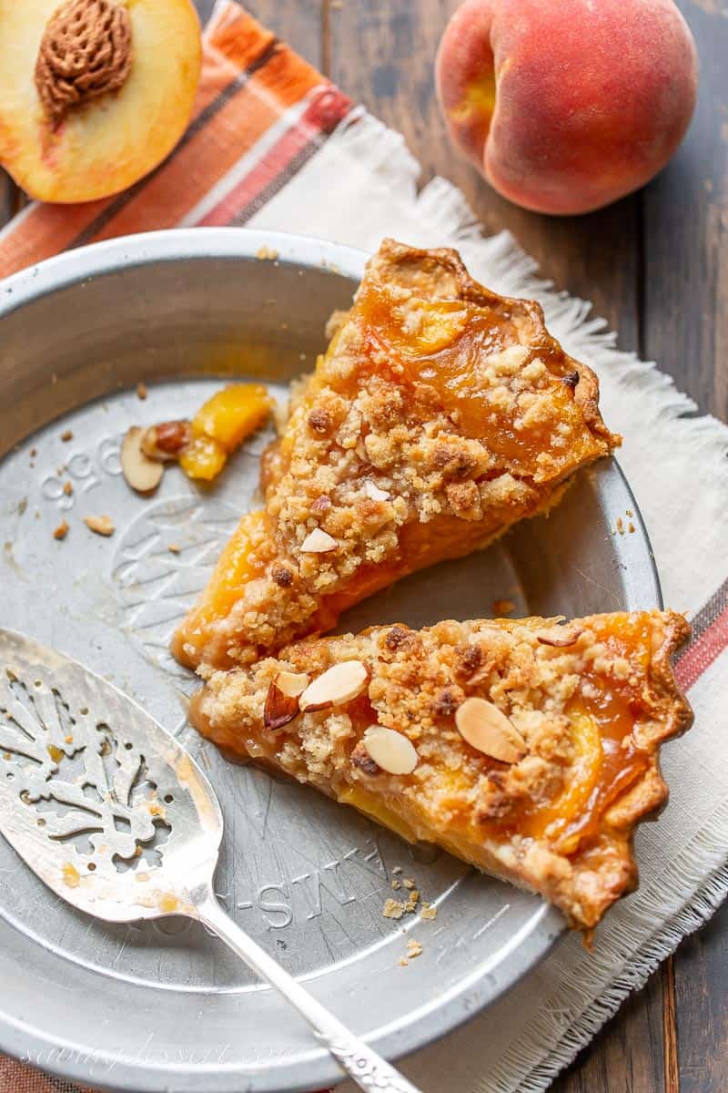 Two slices of peach crumble pie in a pie plate