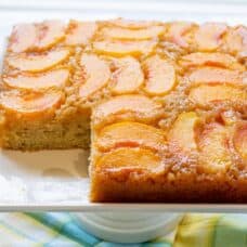 A sliced peach cake on a platter
