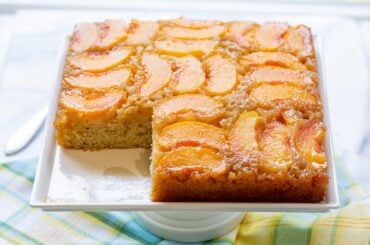 A sliced peach cake on a platter
