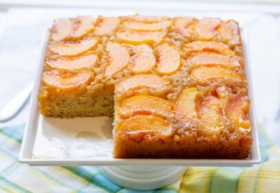 A sliced peach cake on a platter