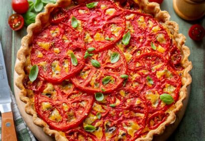 A closeup of a tomato pie topped with basil leaves