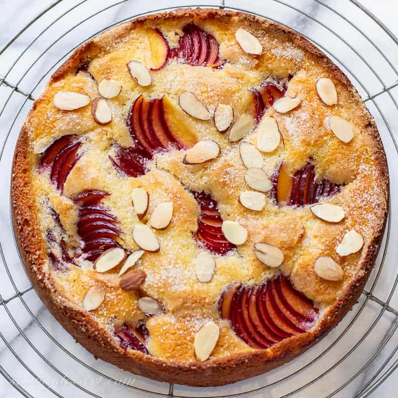 Overhead view of a baked plum cake with almonds on top