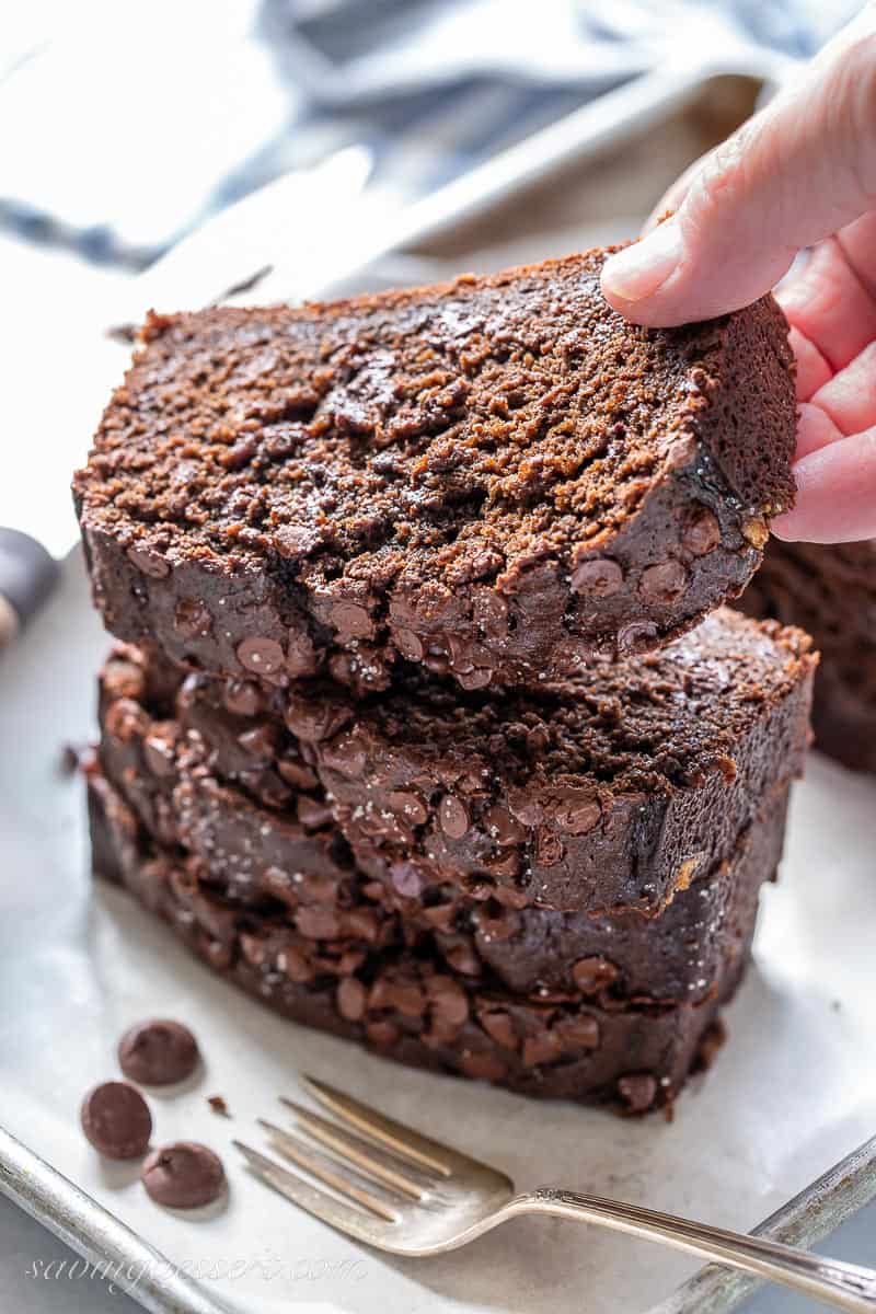 A stack of sliced chocolate banana bread with one slice being removed