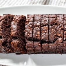 A platter filled with sliced chocolate banana bread topped with mini chocolate chips