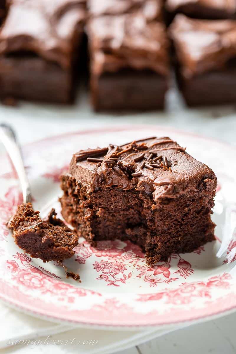 A piece of chocolate cake with a bite taken out with a fork