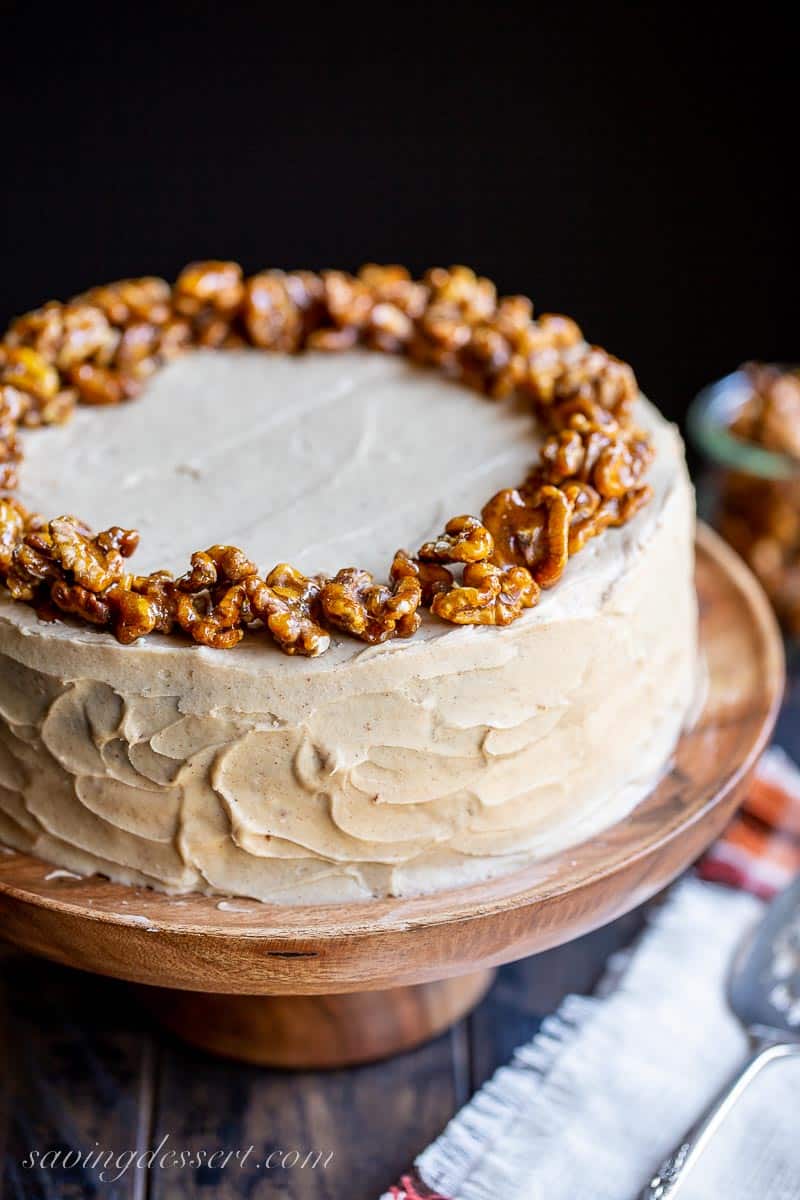 Photo of the top of a brown sugar frosted applesauce cake topped with candied walnuts