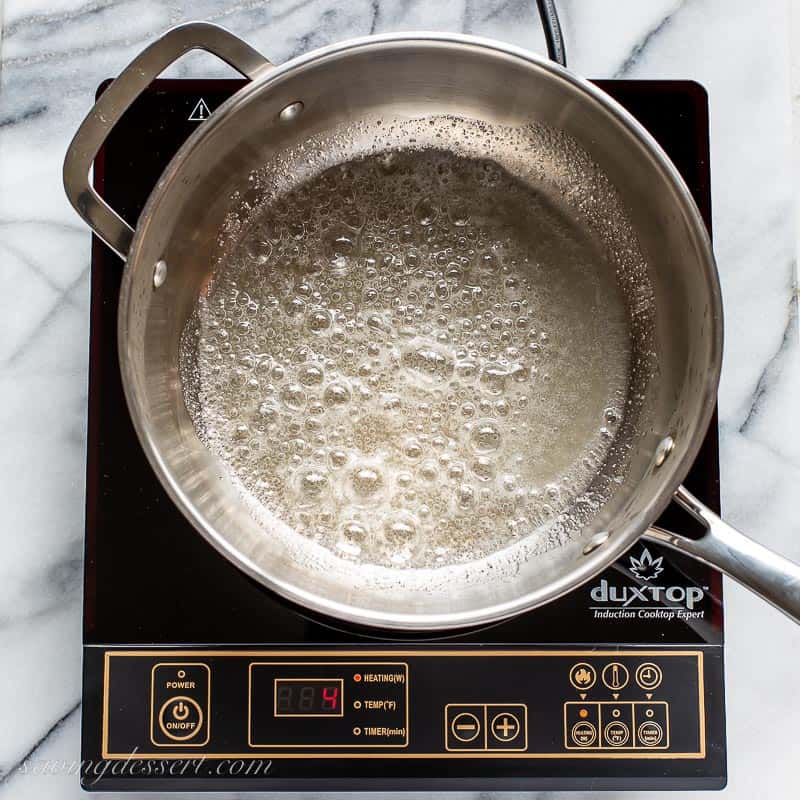 A saucepan with boiling sugar and water