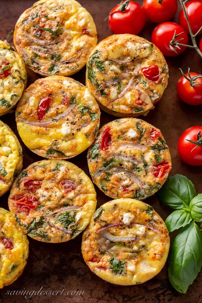Egg muffins with tomato, feta and onion on a baking sheet