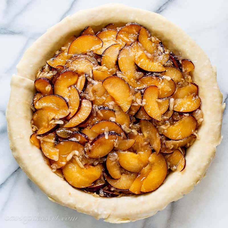 A plum pie being assembled