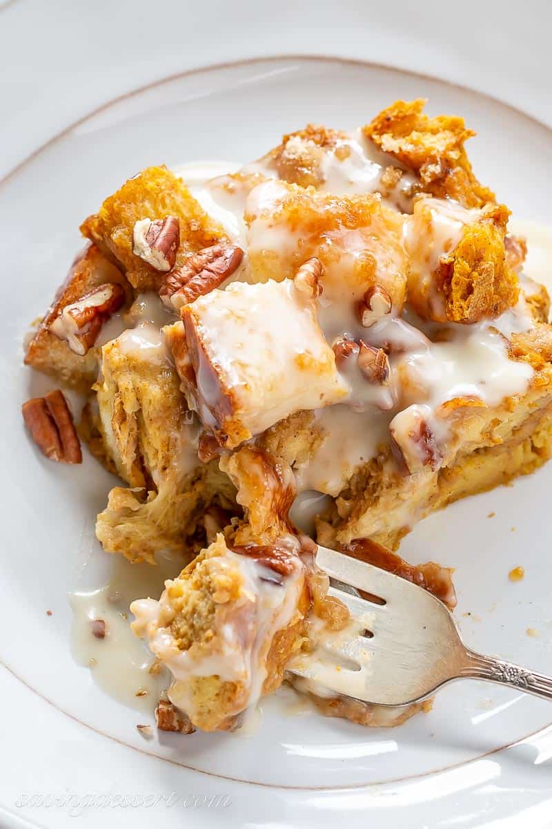 Closeup of a slice of bread pudding with a bourbon cream sauce over the top