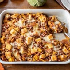 Overhead view of a casserole dish filled with pumpkin bread pudding with pecans on top