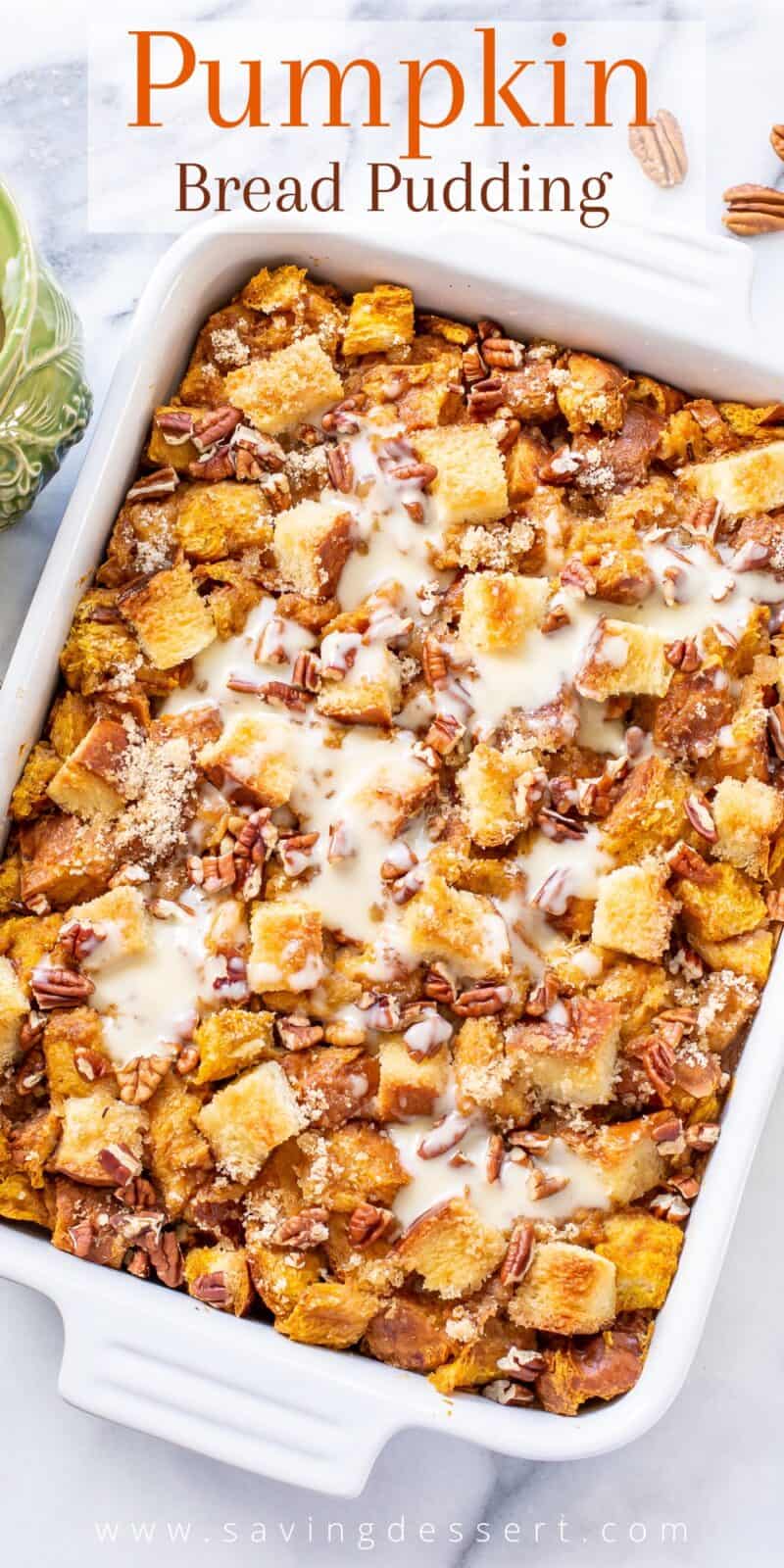 an overhead view of a casserole dish filled with pumpkin bread pudding drizzled with bourbon sauce and toasted pecans