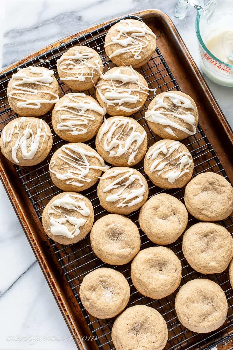 A tray filled with cooled pumpkin spice cookies, half drizzled with icing and half plain