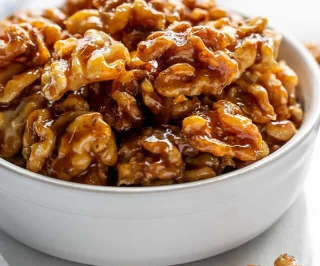 A side view of a bowl of candied walnuts