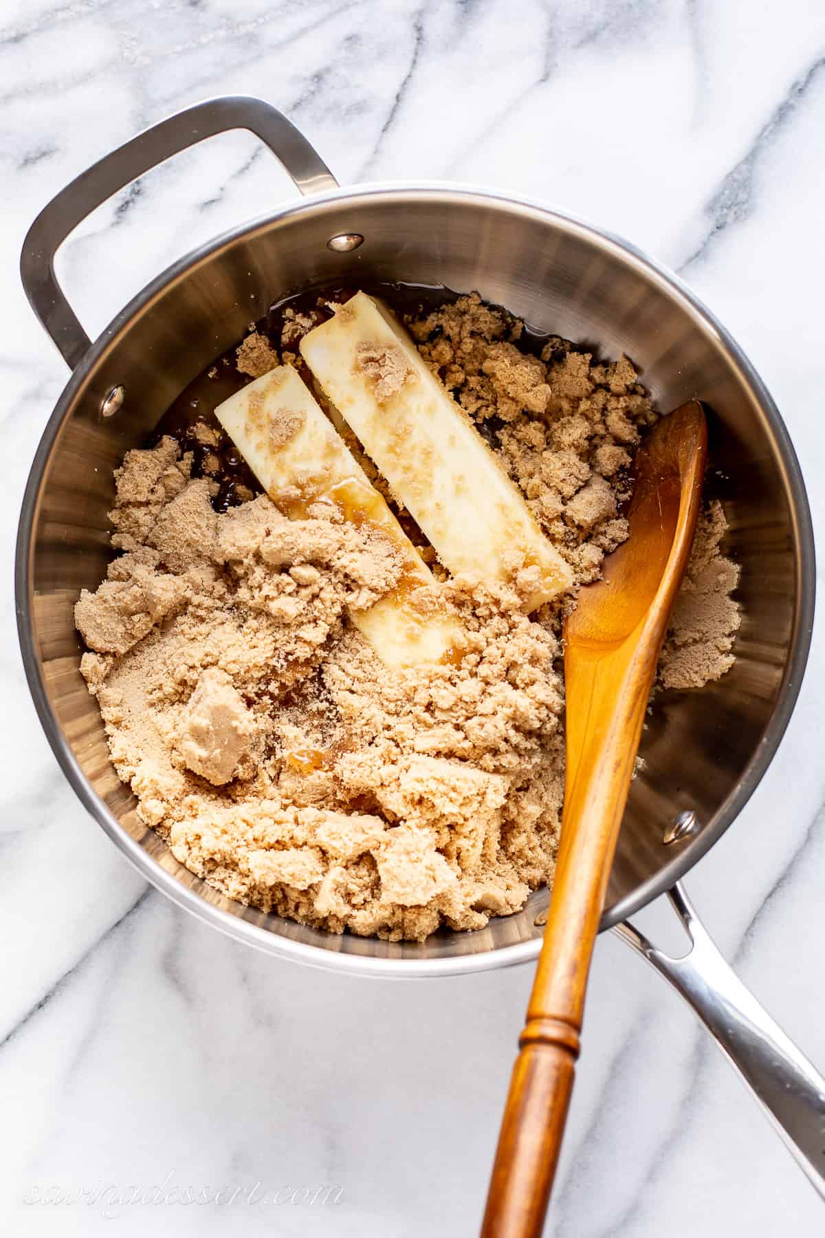 A large saucepan with brown sugar, corn syrup and two sticks of butter