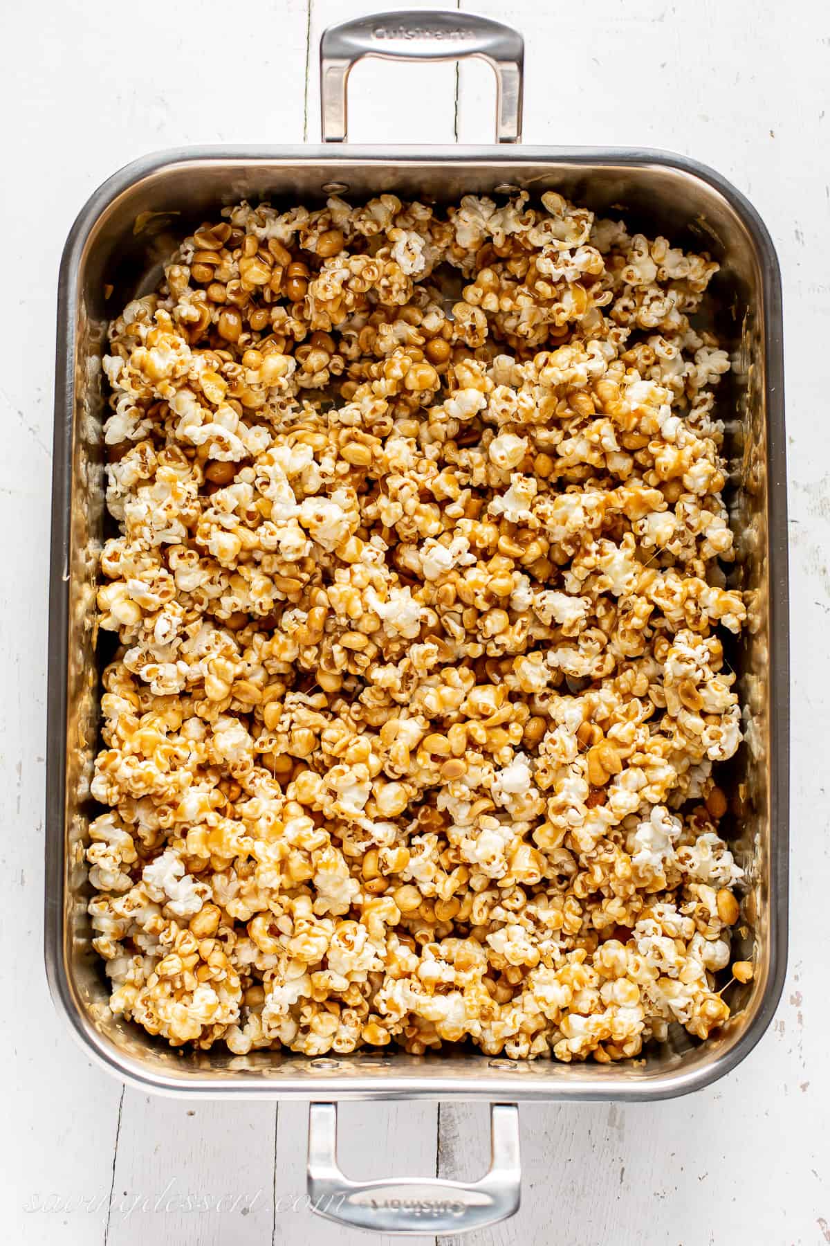 Popcorn in a roasting pan drizzled with the caramel mixture