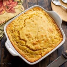 overhead view of a square casserole dish filled with hot corn pudding
