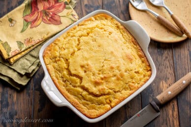 overhead view of a square casserole dish filled with hot corn pudding